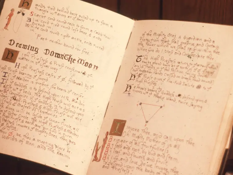 A Book of Shadows open at a hand-copied page, headed “Drawing Down the Moon”.