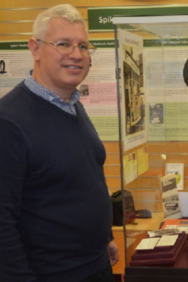 Julian Porter, curator of Bexhill Museum, beside a display case.